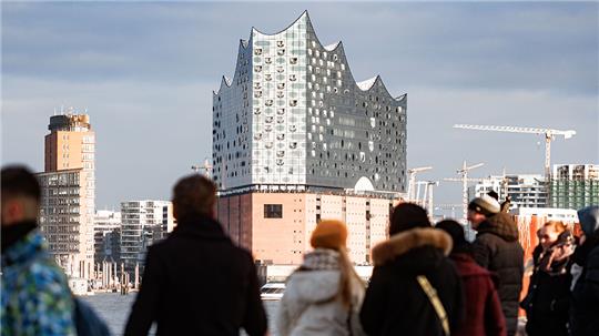 Bei Null Grad Lufttemperatur und Sonnenschein betrachten Besucher vom Bornsteinplatz aus das Panorama der Hansestadt HamburgDie Wolken über der Stadt können durchaus auch noch Schnee bringen. Foto: Markus Scholz/dpa