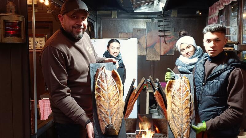 Bei René Bode (links) gibt es frischen Flammlachs. Den servieren Nicolae Edves (von rechts), Cosmina Patracann und Alexandra Edves.