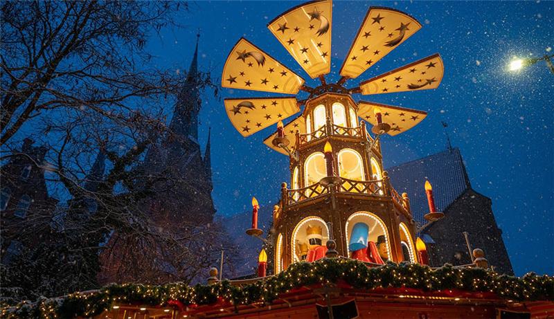 Frivol, maritim, festlich: Weihnachtsmärkte im Norden starten Bei Schneefall leuchtet am Abend auf dem Weihnachtsmarkt die festlich beleuchtete große Weihnachtspyramide. Klassischer Budenzauber, Glühwein mit Blick auf den Hafen, weihnachtliche Zweideutigkeiten oder Schlittschuhlaufen im Lichterglanz - wer im Norden in den nächsten Tagen und Wochen auf den Weihnachtsmarkt gehen möchte, kann zwischen vielen verschiedenen Angeboten entscheiden. Überall stehen die Weihnachtsmarktbetreiber in den Startlöchern oder haben ihre geschmückten und beleuchteten Buden bereits geöffnet. Foto: Benjamin Nolte/dpa