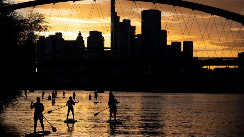 Bilder des Tages Bei Sicht auf die Skyline im letzten Licht des Tages fahren Stand-Up-Paddler in Nähe der Frankfurter Osthafenbrücke über den Main.