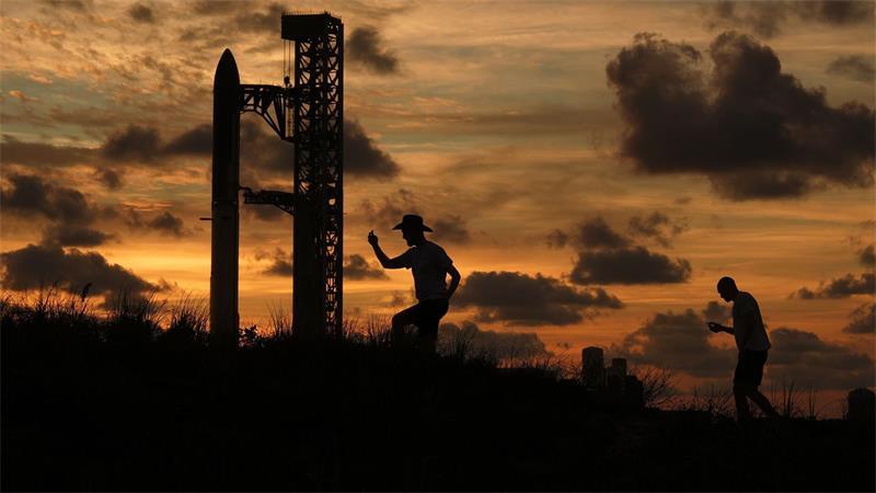 Bei Sonnenuntergang versammeln sich Menschen vor der Mega-Rakete „Starship“.