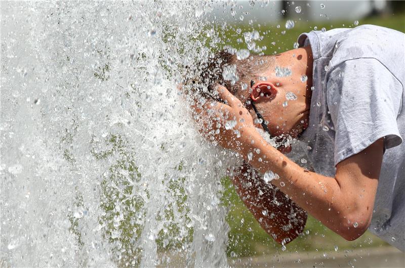 Bei Temperaturen um 29 Grad Celsius erfrischt sich ein junger Mann im Berliner Lustgarten am Wasser eines Brunnens. Hitze kann lebensgefährlich sein – das weisen auch offizielle Statistiken nach. Foto: Wolfgang Kumm/dpa