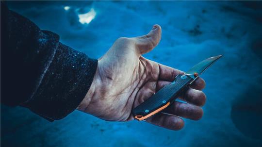 Ein Mann hält ein Messer in der Hand.