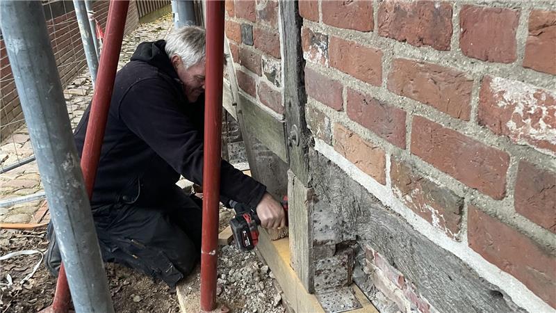 Stavenort in Buxtehude: Wie die Menschen vor 125 Jahren dort lebten Bei der Sanierung des Hauses Stavenort 16 tauscht ein Mitarbeiter der Firma Peters die sogenannte Schwelle (unterster Querbalken unmittelbar auf dem Sockel) aus.