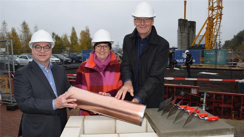 Bei der symbolischen Grundsteinlegung versenken (von links) Gesellschafter Nicolas Mohr, Buxtehudes Bürgermeisterin Katja Oldenburg-Schmidt und geschäftsführender Gesellschafter Jens Saß eine Zeitkapsel aus Kupfer. Diese wird später auf der Baustelle vergraben.