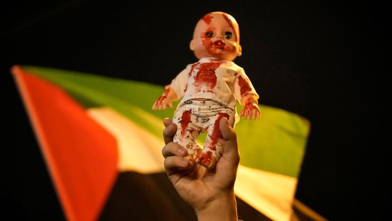 Bei einer pro-palästinensischen Demonstration in Istanbul hält ein Teilnehmer eine rot gefärbte Babypuppe in die Luft.