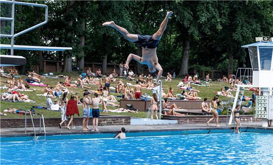 Bei schwülen 31 Grad Lufttemperatur geniessen die Besucher die Abkühlung im Kaifu-Freibad. Foto: Markus Scholz/dpa