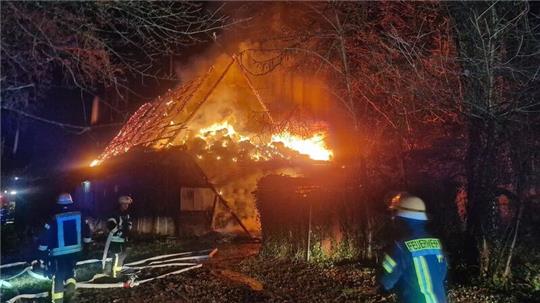 Beim Eintreffen der Feuerwehr brennt das abseits von der Straße liegende Gebäude lichterloh.