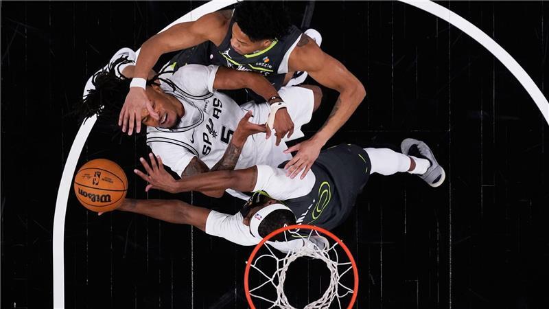 Beim NBA-Spiel der San Antonio Spurs gegen die Minnesota Timberwolves wird Stephon Castle (l) von den Spurs von Mike Conley von den Timberwolves geblockt.