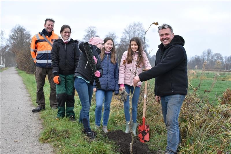 Beim Setzen der Bäume bekommen Lena, Anna Lotta, Sophie und Marie fachkundige Unterstützung vom städtischen Mitarbeiter Andreas Haupt (links) und Gartenbaubetrieb-Inhaber Ingo Diederich. Foto: Weselmann