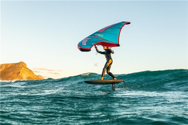 Beim Wingsurfen hält der Surfer auf einem Board stehend einen Wing in der Hand, den er in den Wind stellt, um zu beschleunigen. Foto: Airush Germany