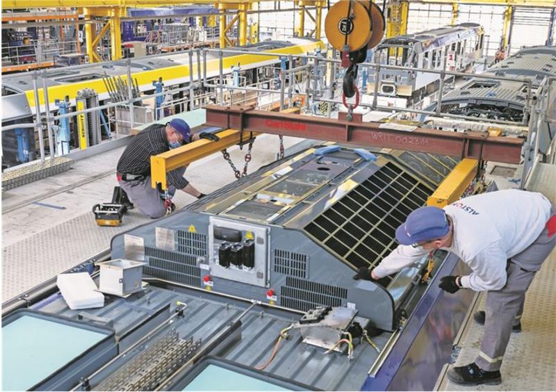 Beim Zughersteller Alstom in Salzgitter hievt in der Produktionshalle ein Kran eine Brennstoffzelle aufs Dach eines Wasserstoffzuges. Die Produktion der 14 Triebfahrzeuge für das Weser-Elbe-Netz der EVB läuft auf Hochtouren. Foto: Busse/Alstom
