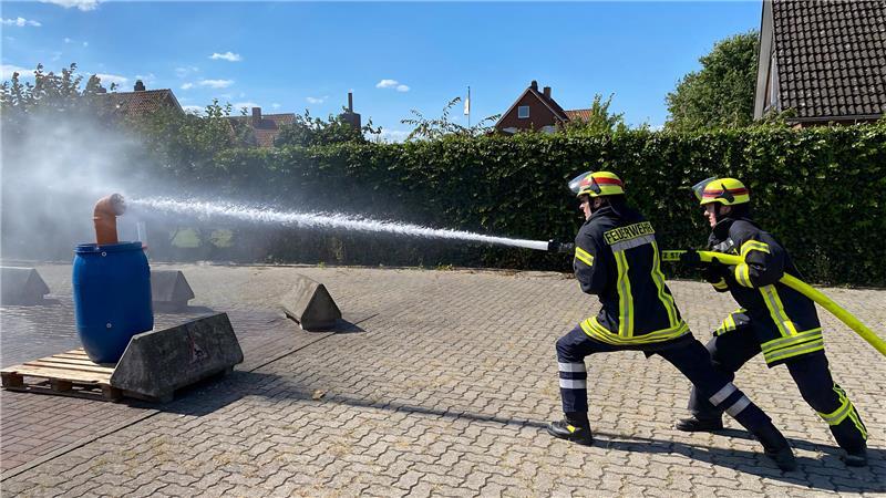 1500 Würste, 1000 Brötchen: Dorf im Kreis Stade wird zum Feuerwehr-Hotspot Beim großen Feuerwehr-Spektakel können die Zuschauer erleben, wie Feuerwehrleute ihre Einsatzfähigkeit im Wettkampf trainieren. Im Bild Jan (links) und Lena Horwege von der Ortsfeuerwehr Assel beim Löschangriff.