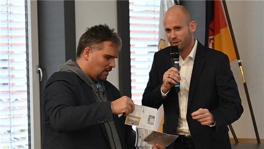 Benjamin Koch-Böhnke (Die Linke) übergibt Sebastian Rauba (rechts) vom Polizeilichen Staatsschutz zwei Postkarten mit Hassbotschaften. Foto: Vasel