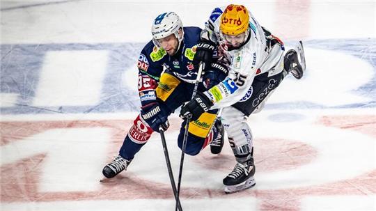 Berlins Frederik Tiffels (l) kämpft gegen Gregory Kreutzer von Pinguins Bremerhaven um den Puck.