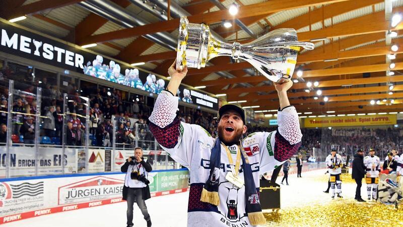 Berlins Yannick Veilleux jubelt nach dem Gewinn der deutschen Eishockey-Meisterschaft mit dem Pokal.