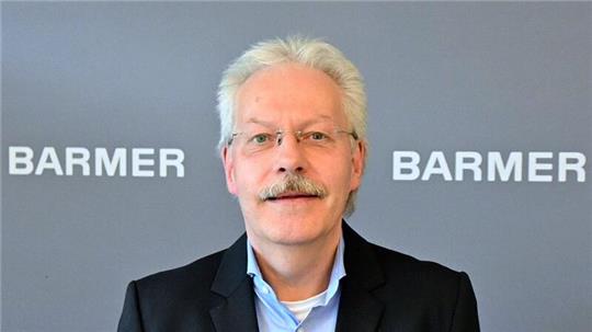 Bernd Hillebrandt, Landesgeschäftsführer der Barmer Krankenkasse in Schleswig-Holstein, steht in einem Büro.