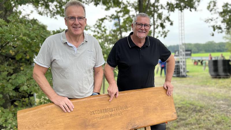 Tonnen an Material: So viel Arbeit steckt im Oktoberfest Revenahe Bernd Meinke (links) und Stephan Perbandt vor der Bank, die der Verein Insel im Moor an den Ort gestiftet hat.