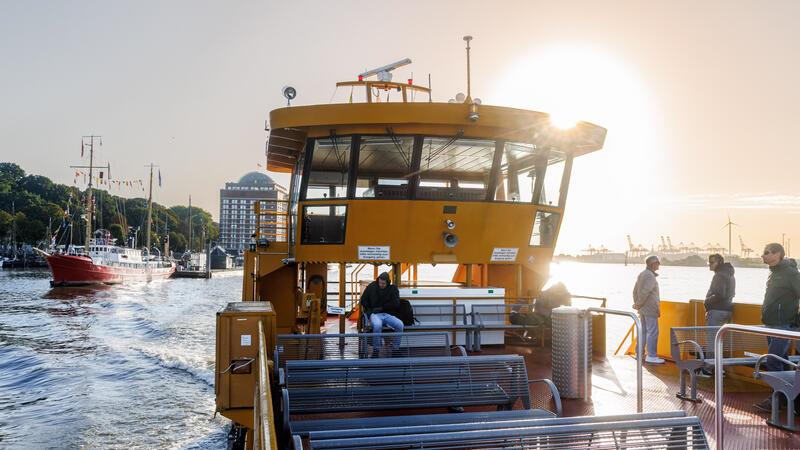 Berufspendler fahren am frühen Morgen auf der Elbe mit der Fähre der Linie 62 von den Landungsbrücken Richtung Finkenwerder.