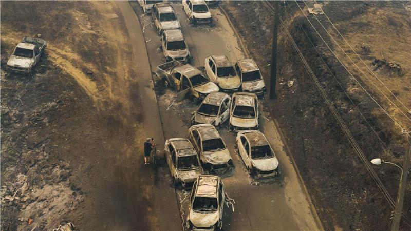 Beschädigte Fahrzeuge säumen eine Straße, nachdem Waldbrände Wohngebiete in Lirquen in Chile verwüstet haben.
