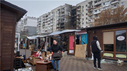 Besitzer kleiner privater Geschäfte räumen die Trümmer auf einem Markt auf.