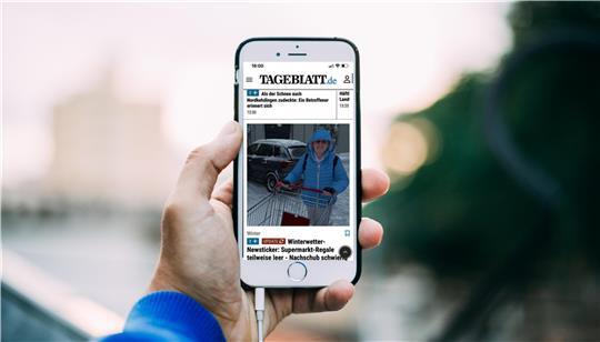 Ein Mann hält ein Smartphone in der Hand.