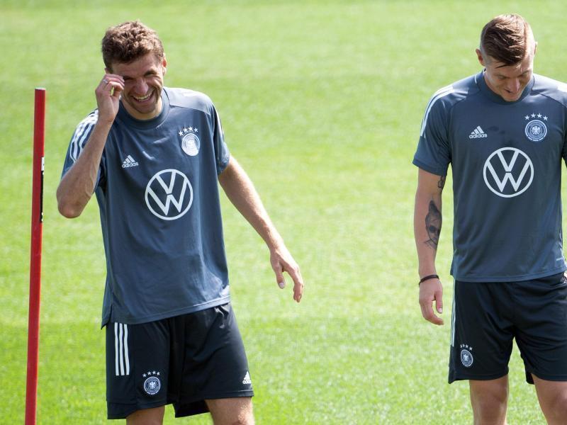 Bestens gelaunt zurück im DFB-Training: Thomas Müller (l) - Toni Kroos freut es auch. Foto: Federico Gambarini/dpa