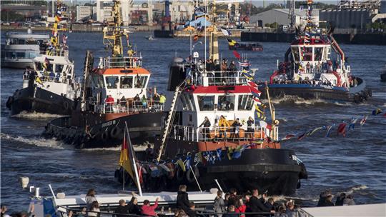 Besucher des Hamburger Hafengeburtstags betrachten 2019 die Schlepper beim traditionellen Schlepperballett, bei dem die Schiffe zur Walzermusik "tanzen". Hamburg feiert mit vielen Höhepunkten in vom 16. bis 18. September 2022 seinen 833. Hafengeburtstag. Foto: Axel Heimken/dpa