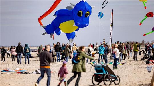 Besucher des Ostseestrandes von Laboe lassen bei Sonnenschein Drachen über den Sandstränden steigen.