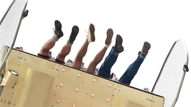 Besucher des Volksfests Cannstatter Wasen in Stuttgart sitzen in einem Fahrgeschäft. Der „Wasen“ ist nach dem Münchner Oktoberfest das zweitgrößte Volksfest in Deutschland.