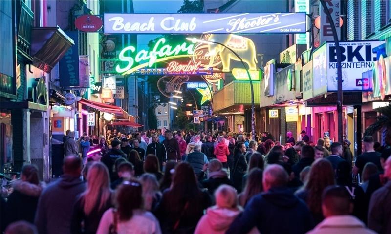 Neue Amazon-Prime-Serie spielt in Hamburg Besucher gehen bei leichtem Regen durch die Große Freiheit auf der Reeperbahn. Foto: Bockwoldt/dpa