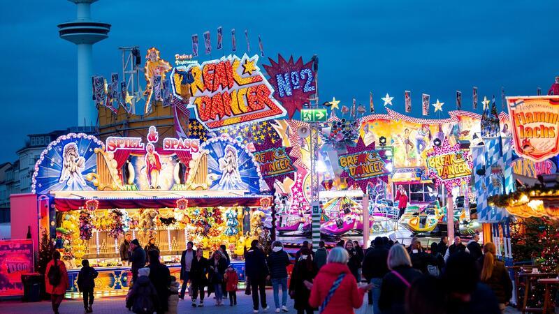 Besucher gehen über das Volksfest „Hamburger Dom“.