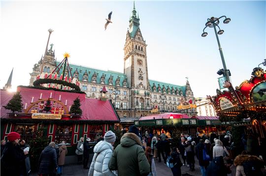 Besucher gehen über den Historischen Roncalli-Weihnachtsmarkt auf dem Rathausmarkt. In Hamburg eröffnen die Weihnachtsmärkte. Foto: Daniel Bockwoldt/dpa