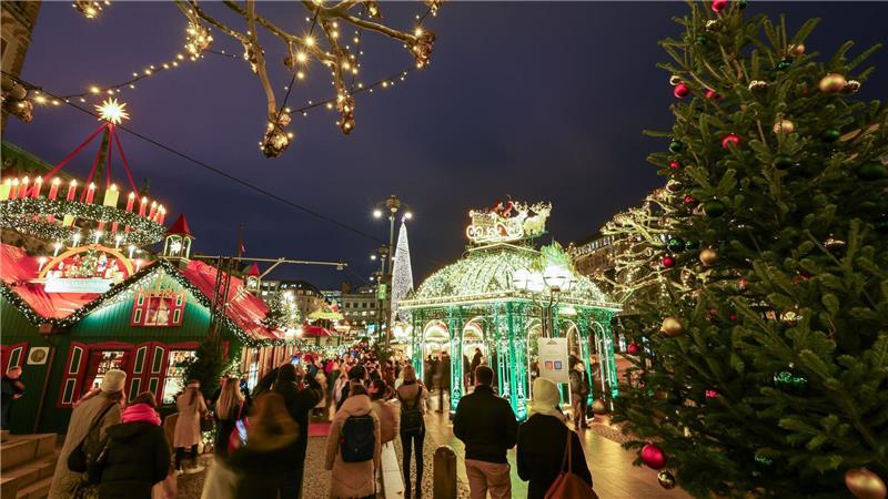 Besucher laufen über den Weihnachtsmarkt.
