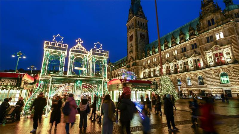 Besucher laufen zum Weihnachtsmarkt in der Innenstadt.
