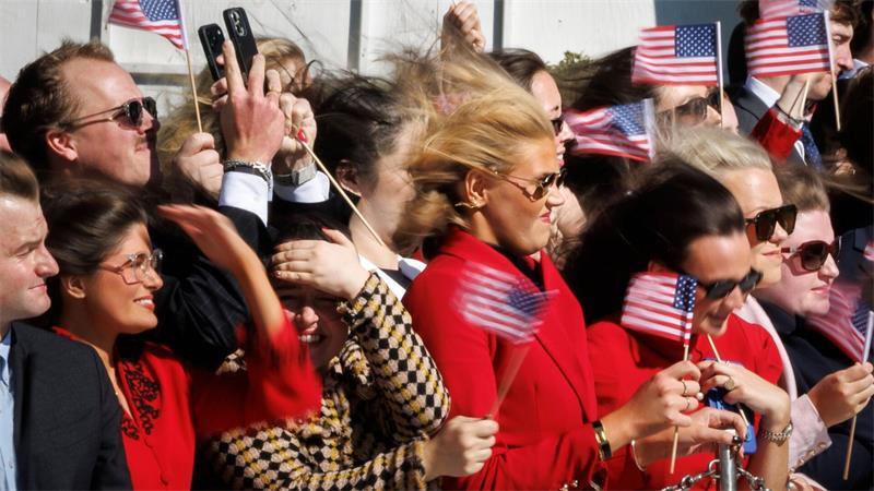 Besucher mit amerikanischen Fahnen beobachten, wie US-Präsident Trump vom Südrasen des Weißen Hauses an Bord der „Marine One“ abhebt.