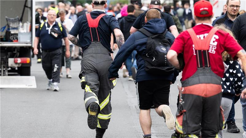 Besucher rennen zu Messebeginn auf der Messe Interschutz, um in Halle 15 einen von 1.000 kostenlosen Rucksäcken am Stand von Haix zu ergattern.
