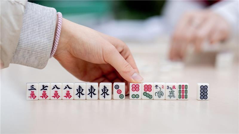 Besucher spielen bei dem chinesisches Neujahrsfest in den Gewächshäusern der Botanika in Bremen das chinesische Gesellschaftsspiel Mah-Jongg.