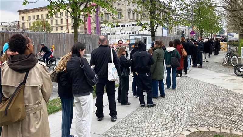 Besucher stehen Schlange vor der Ausstellung.