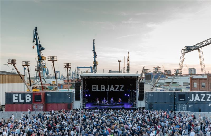 Besucher stehen auf dem Gelände der Werft Blohm und Voss vor der Hauptbühne des Elbjazz-Festivals. Das Festival findet vom 31. Mai bis 1. Juni 2019 statt. Foto: Markus Scholz/dpa