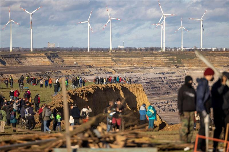 Besucher stehen direkt an der Kante des Tagebaus Garzweiler II in Lützerath.