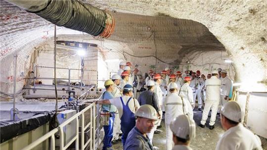 Besucher stehen im Atommülllager Asse neben einem Sammelbecken für radioaktiv belastete Lauge.