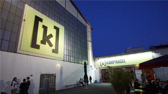 Besucher stehen vor dem Eingang einer großen Foyer-Halle von Kampnagel.
