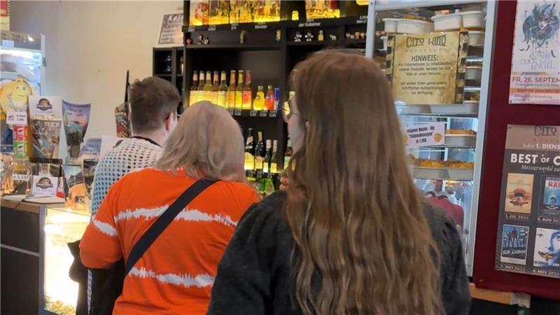 Besucherinnen versorgen sich mit Snacks an der Kinotheke.