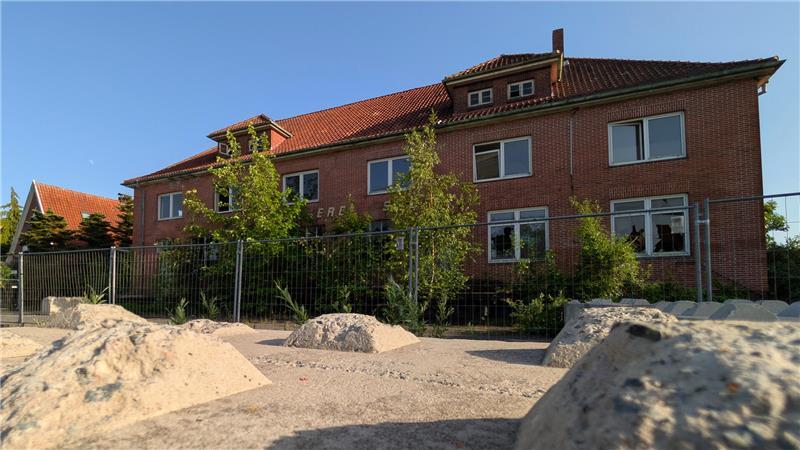 Betonbarrieren und ein großer Bauzaun verzieren die alte Molkerei.