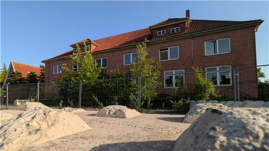 Betonbarrieren und ein großer Bauzaun verzieren die alte Molkerei.