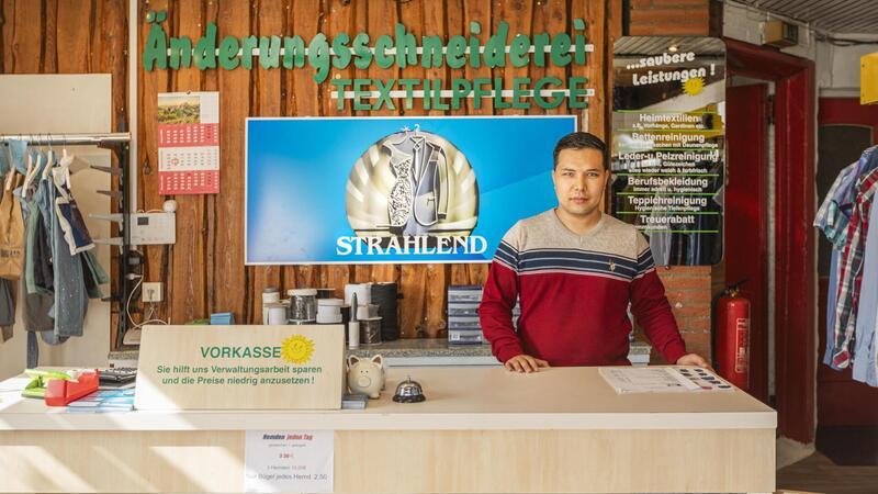 Betreiber Husain Scharifi hinter dem Ladentisch seiner neu eröffneten Änderungsschneiderei „Strahlend“ am Flötenkiel in Bremerhaven.