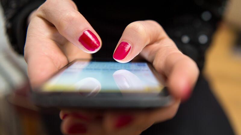 „Love Scam“ und Push-Trick: Senioren um mehr als 100.000 Euro betrogen Eine Frau tippt auf einem Smartphone.