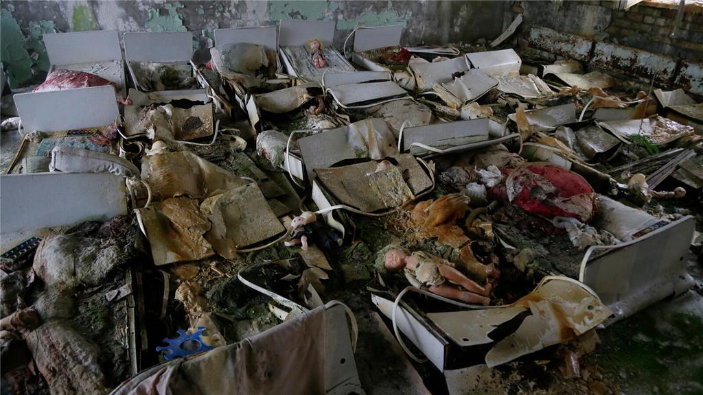 Betten stehen in einem Raum eines verlassenen Kindergartens in der verlassenen S...