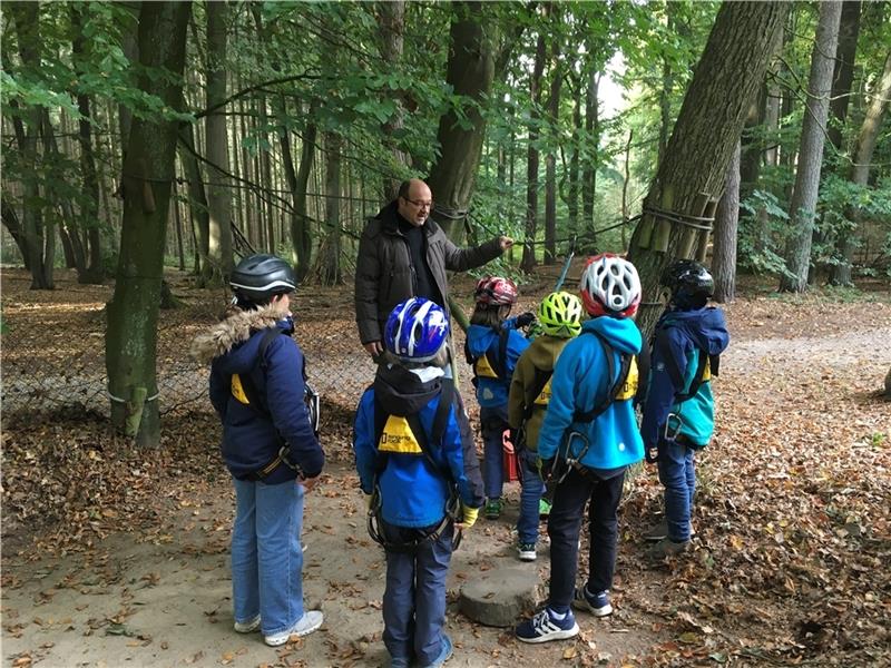 Bevor die Kinder auf gut 1,5 Metern Höhe von einer Station zur anderen klettern, gibt Michael Kreidenberg eine genaue Sicherheitseinweisung.